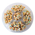 Dog treats with colorful sprinkles in a plastic tray on a white background