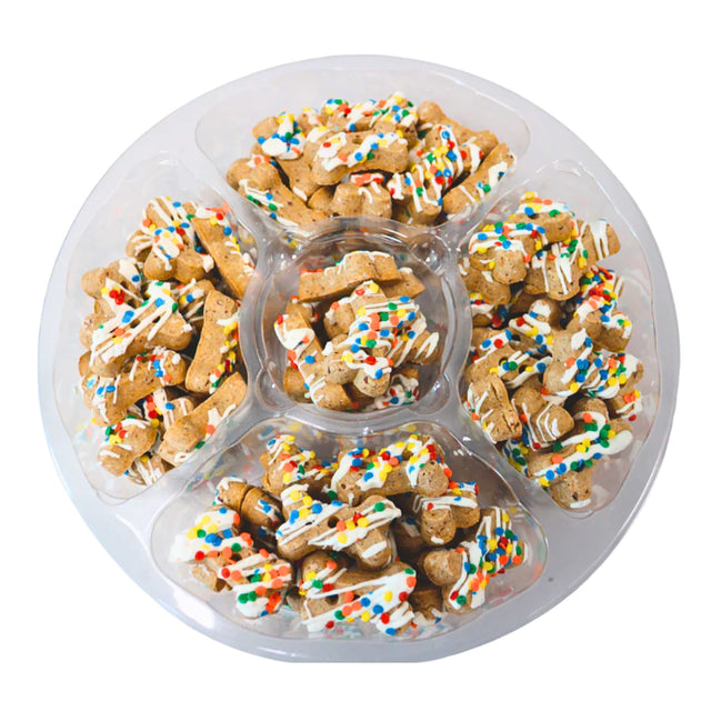 Dog treats with colorful sprinkles in a plastic tray on a white background