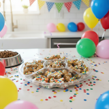 Dog treats with sprinkles on a tray at a birthday party with balloons and confetti.