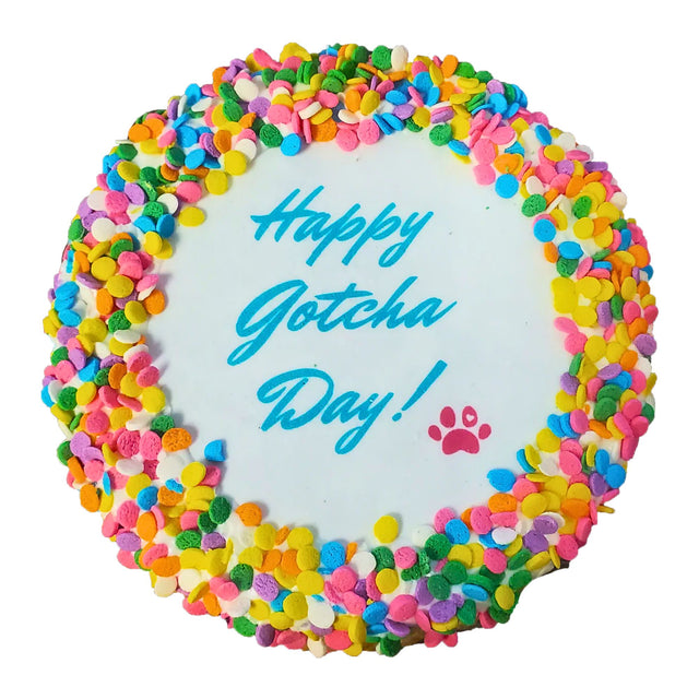 Colorful cake with 'Happy Gotcha Day!' text and paw print on a white background
